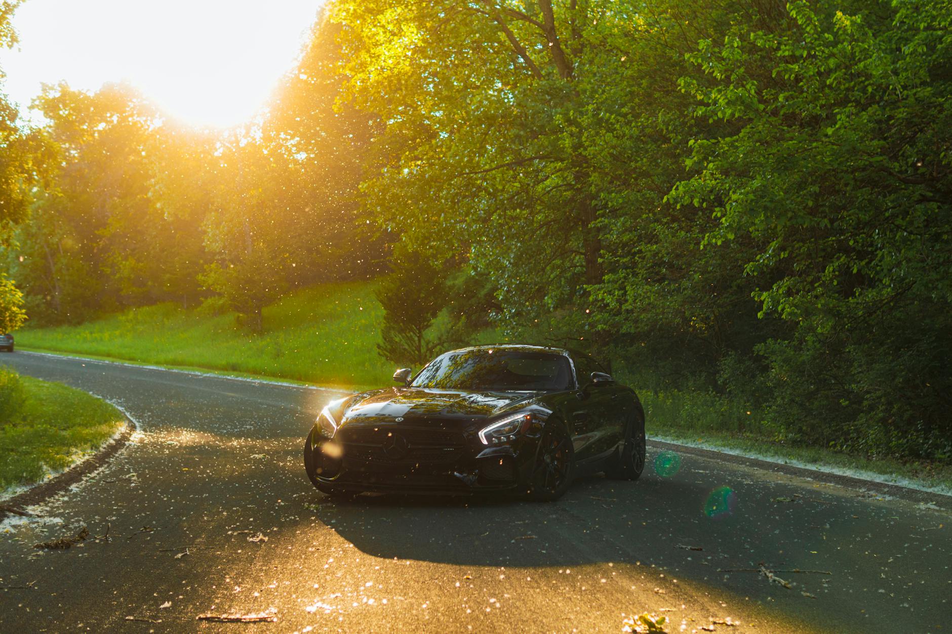 Voiture de sport de prestige sur une route côtière de Guadeloupe au crépuscule